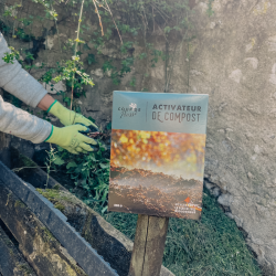 Activateur de compost en situation dans un jardin potager près d'un tas de compost Activateur de compost en situation dans un jardin potager près d'un tas de compost